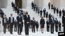 People wait for the casket of the late Supreme Court Justice Ruth Bader Ginsburg to arrive at the U.S. Supreme Court in Washington.