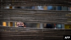 一名戴著口罩的男子在武漢的一個街道上穿過一個障礙物。 (2020年4月3日)