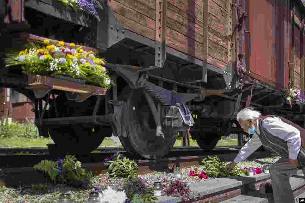 A man lays flowers on rusty railway tracks at the Naujoji Vilnia railway station in Vilnius as Lithuania marks the 80th anniversary of mass deportation by the Soviet Union. Some 280,000 people were deported to Siberian gulags, a year after Soviet troops had occupied the Baltic nation.