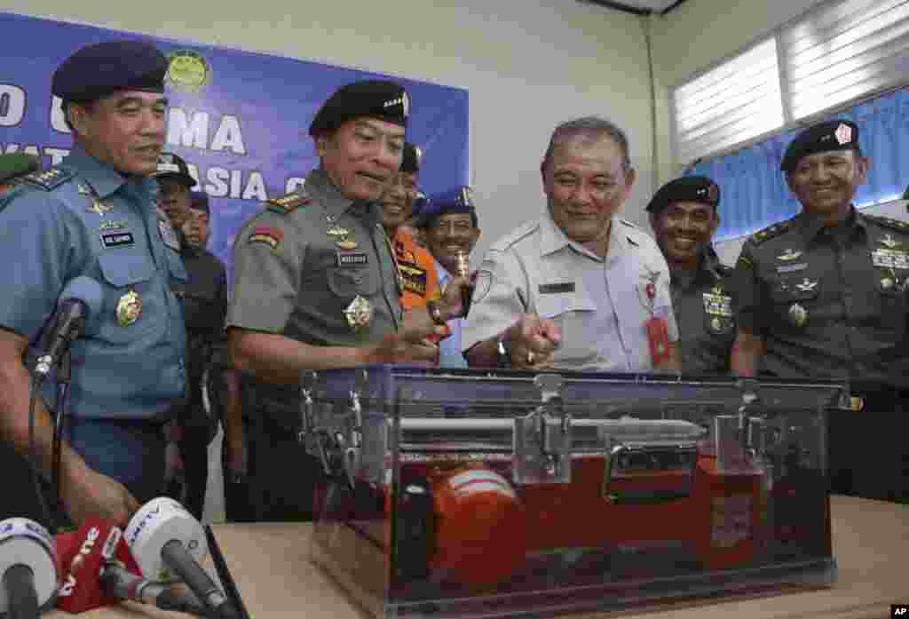 Panglima TNI Jenderal Moeldoko (tengah, kiri) dan Kepala Komite Nasional Keselamatan Transportasi Tatang Kurniadi (tengah, kanan), melihat salah satu kotak hitam AirAsia 8501 dalam konferensi pers di bandar udara di Pangkalan Bun (12/1).