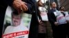 Alyssa Edling, center, and Thomas Malia, second from right, both with PEN America, join others as they hold signs of missing journalist Jamal Khashoggi, during a news conference about his disappearance in Saudi Arabia, Oct. 10, 2018, in front of The Washington Post in Washington. 