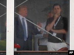 President Donald Trump talks with his son Eric Trump, right, while looking over the 15th green from his viewing platform during the second round of the U.S. Women's Open Golf tournament, July 14, 2017, in Bedminster, N.J.