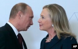 Russian President Vladimir Putin, left, speaks to U.S. Secretary of State Hillary Rodham Clinton on her arrival at the APEC summit in Vladivostok, Russia, Sept. 8, 2012.