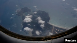Pesawat Angkatan Udara Vietnam AN-26 terbang di atas pulau Con Dao untuk mencari pesawat Malaysia Airlines penerbangan MH370 (12/3). (Reuters/Kham)