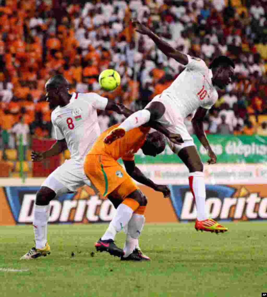 Zokora of Ivory coast fights for the ball with Kere and Traore of Burkina Faso during their African Nations Cup soccer match in Malabo