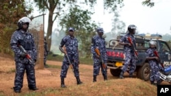 A line of riot police prevent the media and others from approaching Uganda's main opposition leader Kizza Besigye, who was placed under house arrest at his home in Kasangati, Uganda, Feb. 22, 2016. Police said they will lift the blockade Friday.