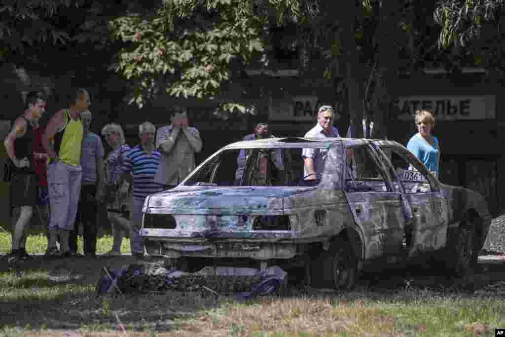 Yerli sakinlər Ukrayna ordusunun hücumu zamanı yanmış avtomobilə tamaşa edir - Slavyansk, 28 may, 2014 &nbsp;