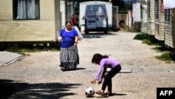 A woman, member of the Roma community, walks at the "River Village" Roma camp, managed by the Onlus Isola Verde association, June 19, 2018, on the outskirts of Rome, Italy.
