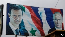 Cartazes do Presidente sírio, Bashar al-Assad, ao lado do Presidente russo, Vladimir Putin,Em Aleppo, na Síria, Jan. 18, 2018.