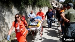 Petugas medis mengangkut korban luka-luka akibat gempa di Pescara del Tronto, Italia tengah, Rabu (24/8).