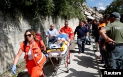 An injured person is carried away on a stretcher following an earthquake at Pescara del Tronto, central Italy, Aug. 24, 2016.