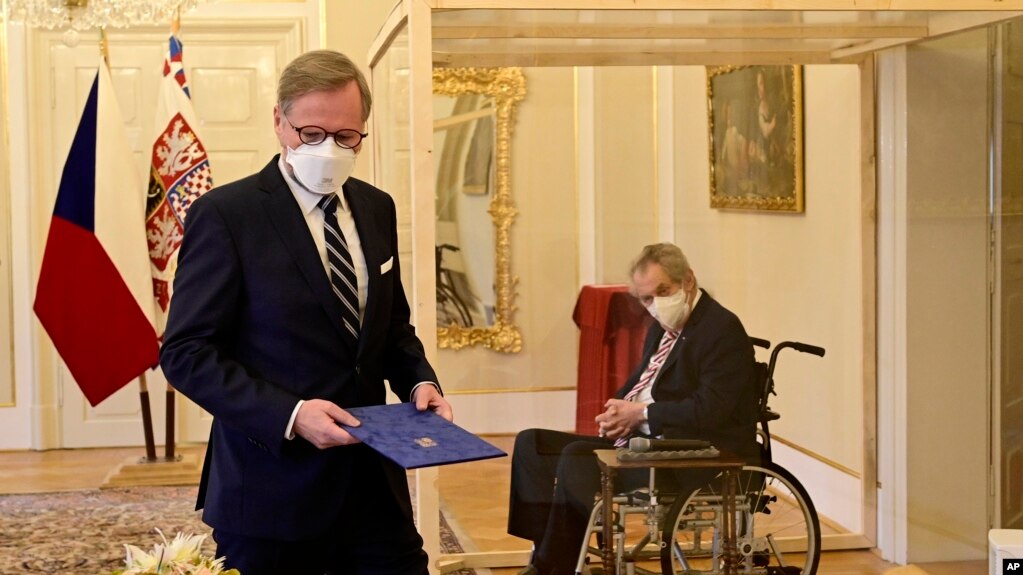 坐在有机玻璃隔间的捷克总统米洛斯·泽曼任命菲亚拉（左）为总理。(photo:VOA)