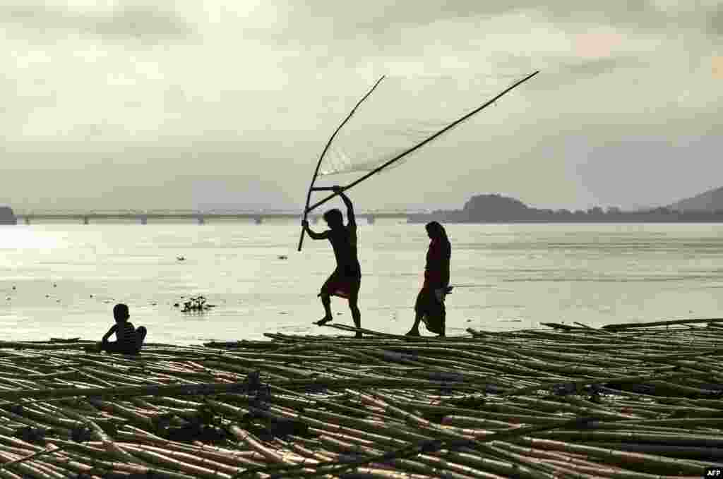 A man fishes on floating bamboo logs in the Brahamaputra river in Guwahati in the northeastern state of Assam, India.