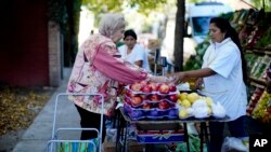 Una mujer compra frutas en un mercado callejero en Buenos Airres, Argentina, el 16 de abril de 2019.