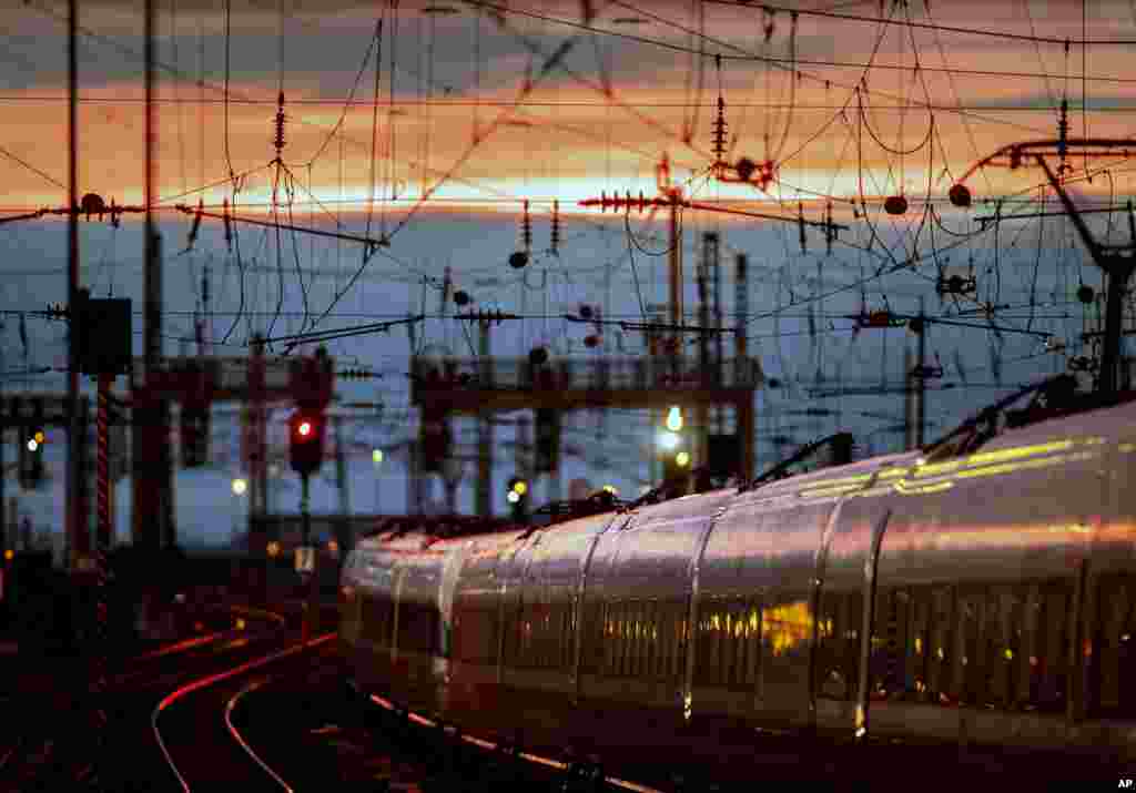 A train leaves the main train station after the sun sets in Frankfurt, Germany.