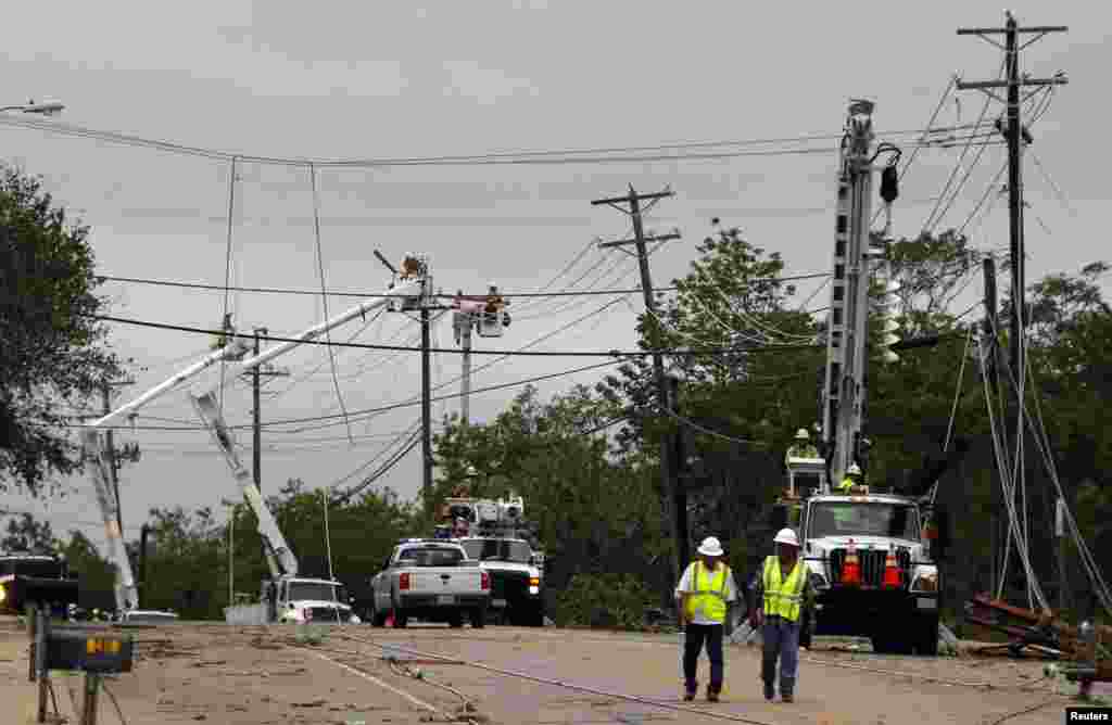 Utility workers attempt to repair power lines and restore power to a neighborhood after a tornado in Cleburne, Texas May 16, 2013. 