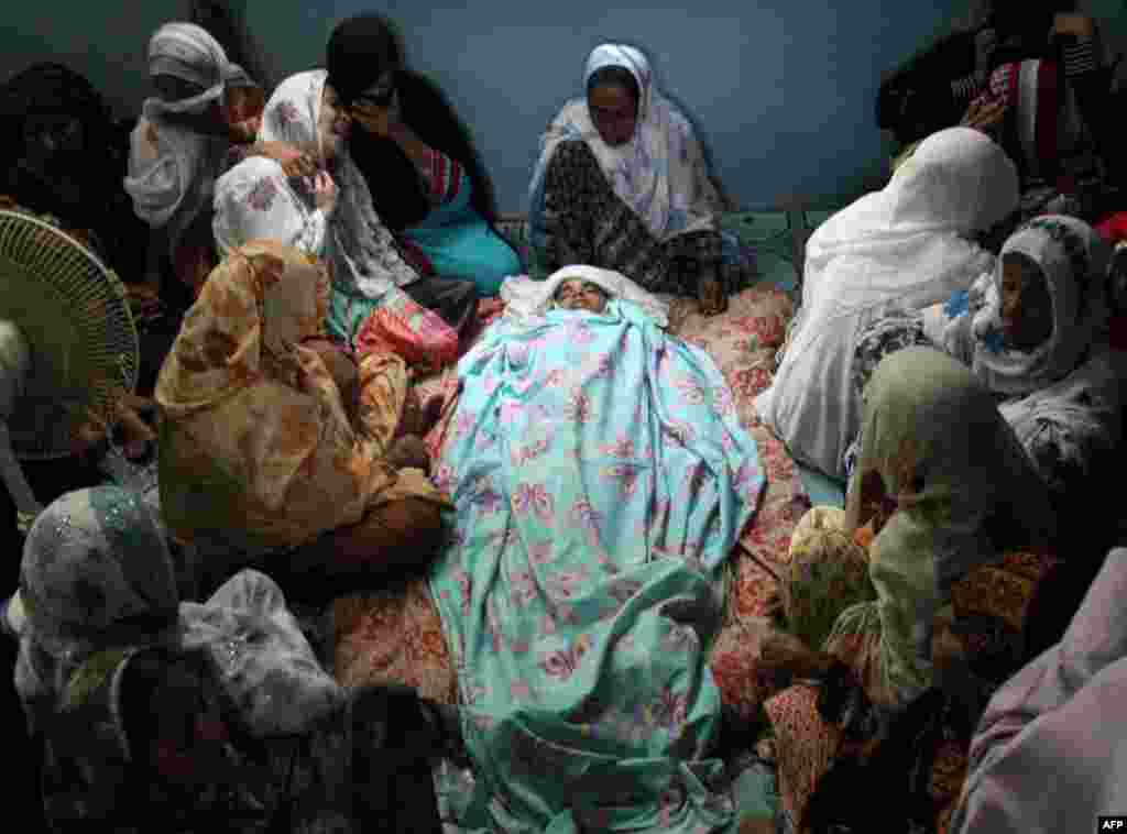 Mourners gather around the body of Abdul Basit, who was killed in a bomb blast in Karachi, Pakistan, August 7, 2013. 