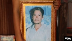 An unknown person holds a photo of Tuy Sros, 34, in a home in Banteay Meanchey province's Ou Chrov district's Chrey village, Phnom Penh, Cambodia, January 20, 2020. (Sun Narin/VOA Khmer) 