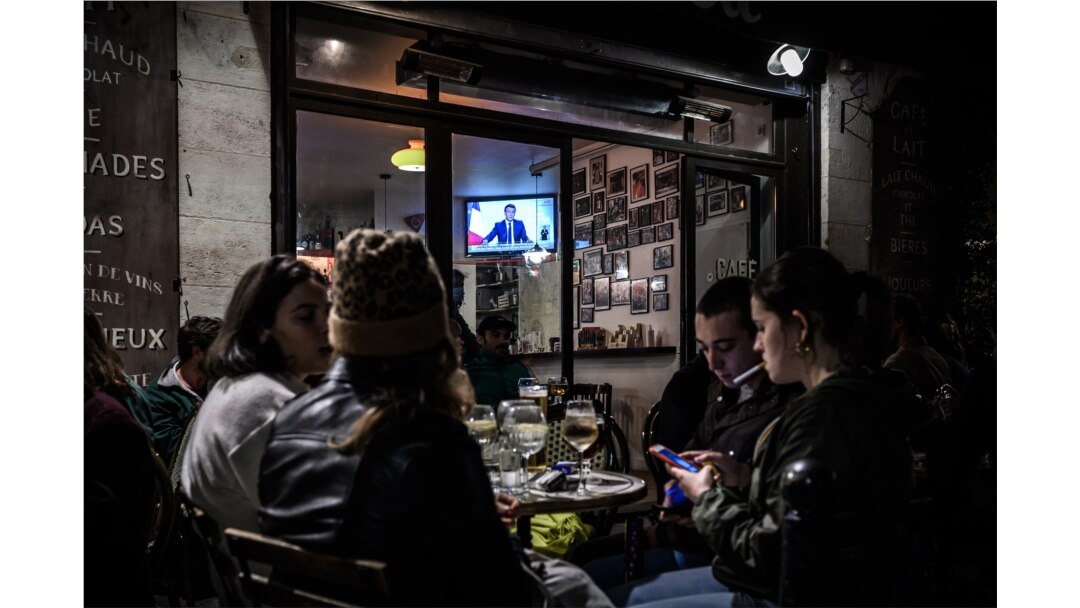 Para pengunjung kafe di Bordeaux, Perancis selatan, menikmati suasana di teras kafe tersebut, sambil menyimak pidato Presiden Emmanuel Macron soal restriksi baru untuk menekan laju penularan virus Covid-19, Rabu malam, 28 Oktober 2020.