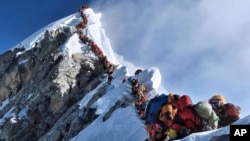 In this photo made on May 22, 2019, a long line of mountain climbers line a path on Mount Everest. (Nirmal Purja/@Nimsdai Project Possible via AP)
