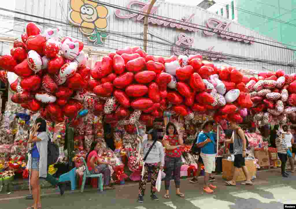 فروشندگان در بازار گل فروشی در مانیل فیلیپین با فروش&nbsp; انواع بالن ها و دسته های گل به استقبال روز والنتاین می روند. &nbsp;