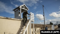 Des policiers surveillent l'entrée d'un abri pour les personnes infectées par le coronavirus à Toamasina, Madagascar, le 3 juin 2020. (Photo by RIJASOLO / AFP)