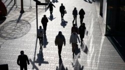 Visitors to a shopping mall cast shadows as they walk through a health check point in Beijing, China, Dec. 14, 2021.