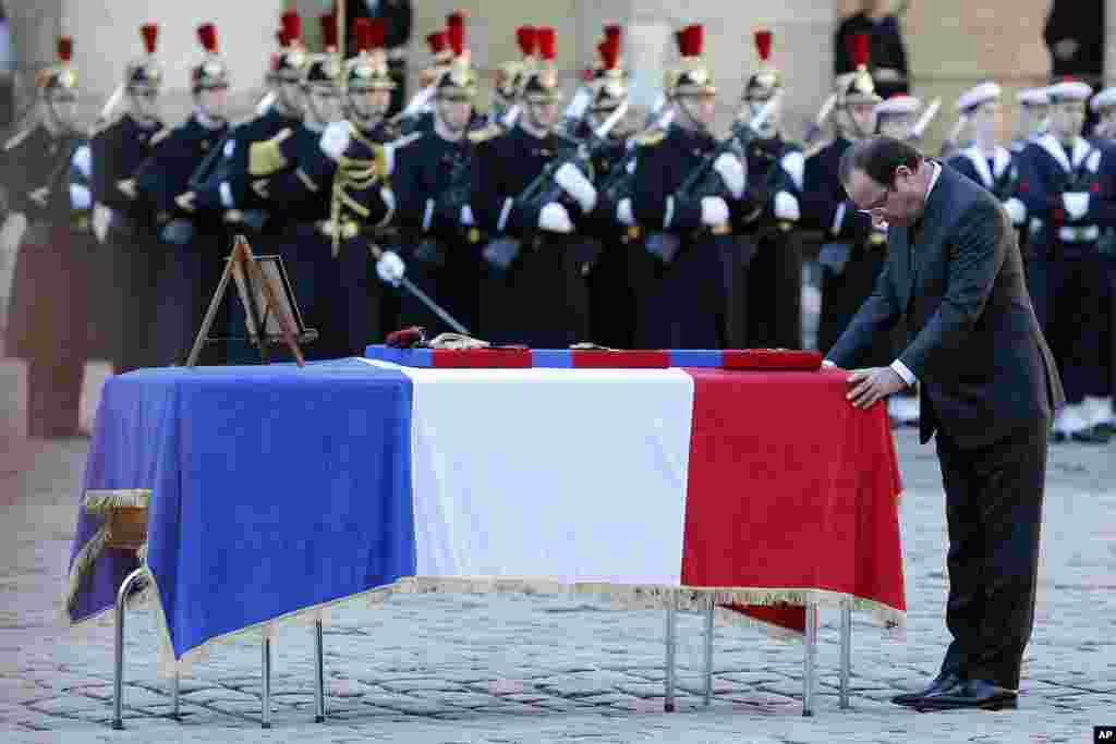 French President Francois Hollande pays his respect at the coffin of one of the two soldiers that died on Dec. 9 in Central African Republic, at the Invalides in Paris. 