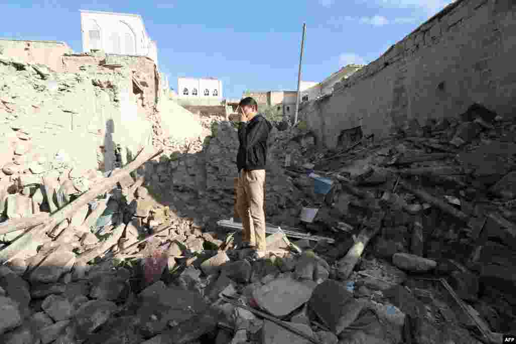 A Syrian man stands on top of rubble following an overnight rocket attack on the contested Bab al-Hadid neighborhood of the northern city of Aleppo.