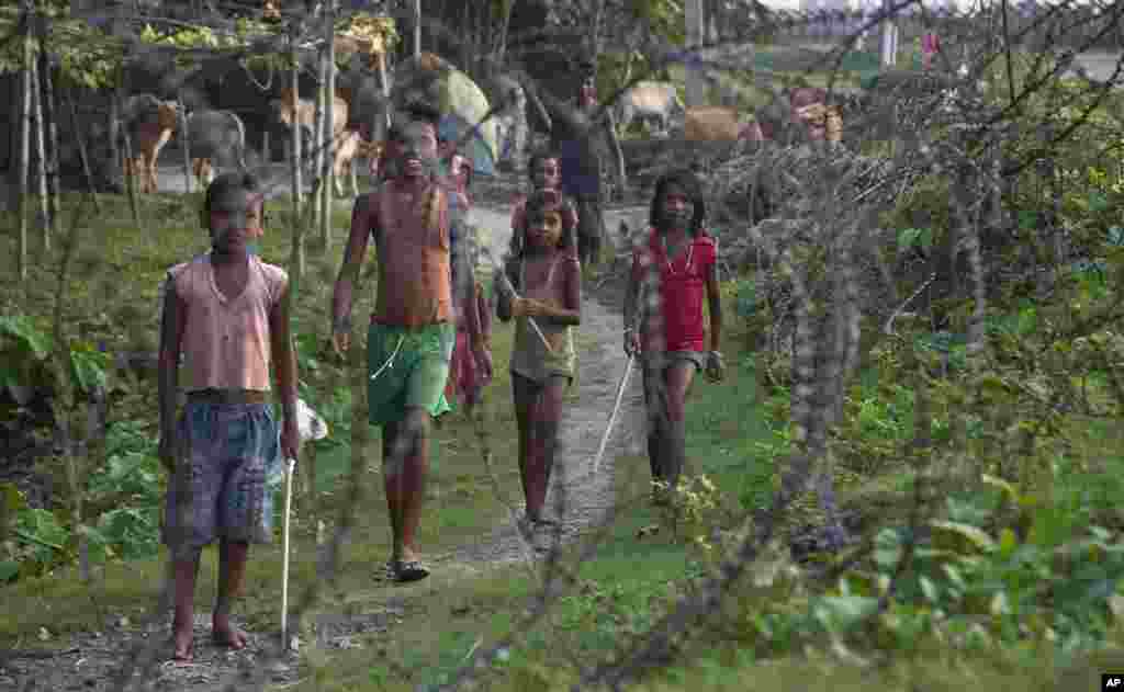 Indian children stand by a fence on the India-Bangladesh border at Jhalchar, in the northeastern Indian state of Assam.