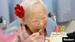 FILE - Japanese Misao Okawa, the world's oldest woman, eats her birthday cake as she celebrates her 116th birthday in Osaka, western Japan, in this photo taken by Kyodo March 5, 2014. 