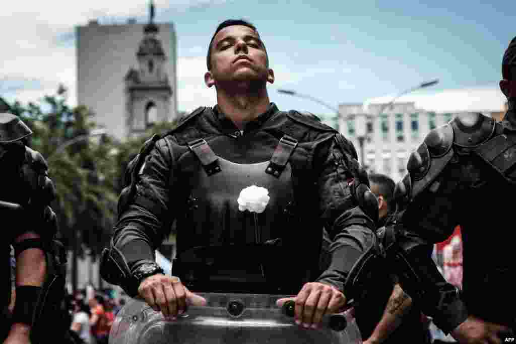 A riot police officer bearing a white flower on his bulletproof vest takes part in a public servants&#39; protest against austerity measures in front of the Rio de Janeiro state Assembly (ALERJ) in Rio de Janeiro, Brazil, Dec. 12, 2016.