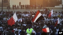 Supporters of the Shiite opposition Al-Wefaq society wave red-and-white Bahraini flags and a Yemeni flag during a rally in Tubli, Bahrain, near the capital of Manama, September 22, 2011.