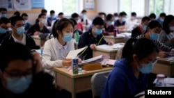 Students wearing face masks are seen inside a classroom during a government-organized media tour at a high school as more students returned to campus following the coronavirus disease outbreak, in Shanghai, China May 7, 2020. (REUTERS/Aly Song)