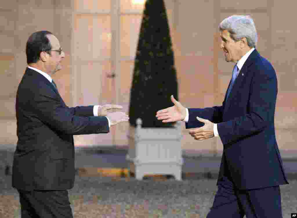 Presiden Perancis Francois Hollande menyambut Menteri Luar Negeri AS John Kerry di Istana Elysee Palace di Paris (16/1). ​(AP/Jacques Brinon)