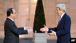 France's President Francois Hollande, left, welcomes U.S. Secretary of State John Kerry to the Elysee Palace in Paris, Jan. 16, 2015.