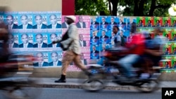 A wall is blanketed with campaign posters promoting electoral candidates, in Port-au-Prince, Haiti, Oct. 7, 2015. 