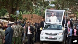Pope Francis waves to local residents as he drives to St. Joseph The Worker Catholic Church in the Kangemi slum of Nairobi, Kenya Friday, Nov. 27, 2015.