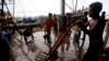 Người lao động nhập cư dỡ bỏ cá đông lạnh từ một chiếc thuyền tại chợ cá trong tỉnh Samut Sakhon, phía tây Bangkok, Thái Lan.