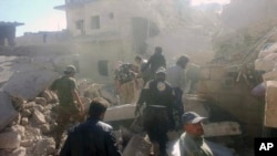 This photo provided by the Syrian Civil Defense White Helmets, which has been authenticated based on its contents and other AP reporting, shows Civil Defense workers and Syrian citizens inspecting damaged buildings after airstrikes hit in Darat Izza town, in rural western Aleppo province, Syria, Saturday, Nov. 5, 2016.