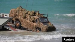 FILE - An Australian troop transporter wades onto Langham beach during military exercises in Queensland, northeast Australia, July 13, 2017.
