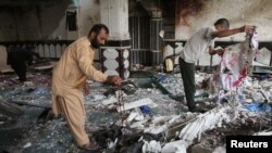 Relatives inspect the damage after an overnight suicide attack at a mosque in Herat, Afghanistan, Aug. 2, 2017. 