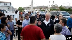 Tổng thống Donald Trump và Thống đốc Puerto Rico Ricardo Rosselló (đội nón, giữa) trò chuyện với người dân và đi thị sát thiệt hại do bão Maria gây ra ở Guaynabo, Puerto Rico, ngày 3 tháng 10, 2017. 