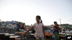 A girl cooks snacks to sell in Myoma market at Naypyitaw, Burma, December 18, 2011.