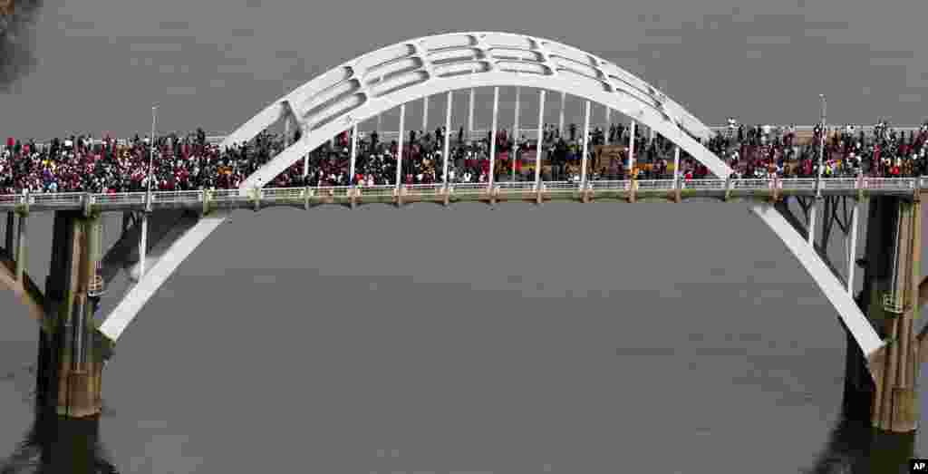 پیاده&zwnj;روی نمادین مردم بر روی پل ادموند پتوس در سلما، آلاباما در پنجاهمين سالگرد راهپیمایی حقوق مدنی &laquo;يکشبه خونين&raquo; که توسط پليس مورد ضرب و شتم قرار گرفته بود - ۱۷ اسفند ۱۳۹۳ (۸ مارس ۲۰۱۵)