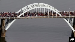FILE - In this aerial photo, crowds of people move in a symbolic walk across the Edmund Pettus Bridge, Sunday, March 8, 2015, in Selma, Alabama.