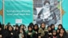 Iranian women pray in front of a a poster of Iran's late founder of the Islamic Republic, Ayatollah Ruhollah Khomeini, on the occasion of 40th anniversary of Khomeini's return from exile from Paris at his mausoleum in southern Tehran, Feb. 01, 2019. 