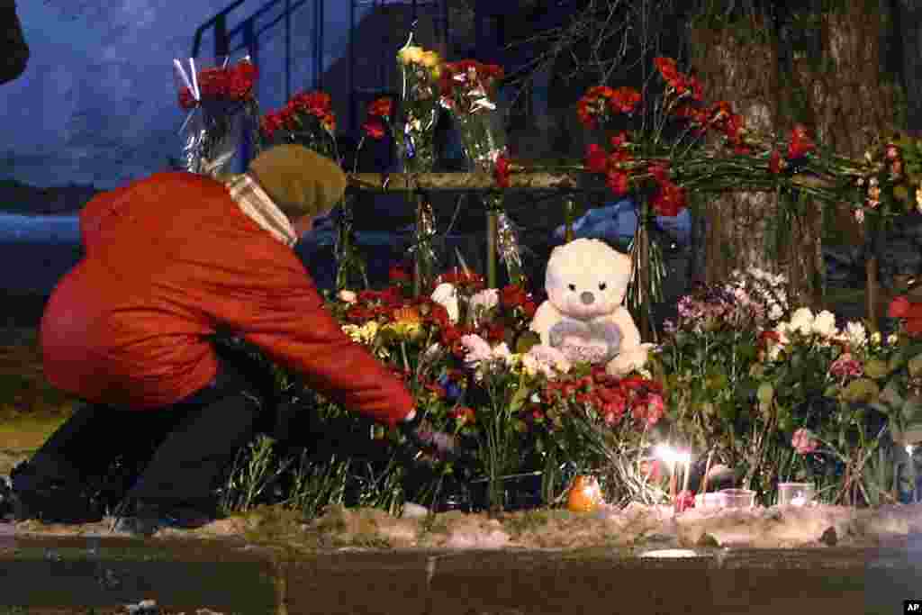 A woman puts a flower outside wreckage of a trolleybus, Volgograd, Russia, Dec. 31, 2013. 