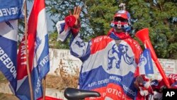 FILE - A supporter of the New Patriotic Party (NPP) wears campaign paraphernalia on the side of a road in Accra, Ghana, Nov. 23, 2012. The NPP won its challenge to qualify a candidate for the December 7 presidential election.