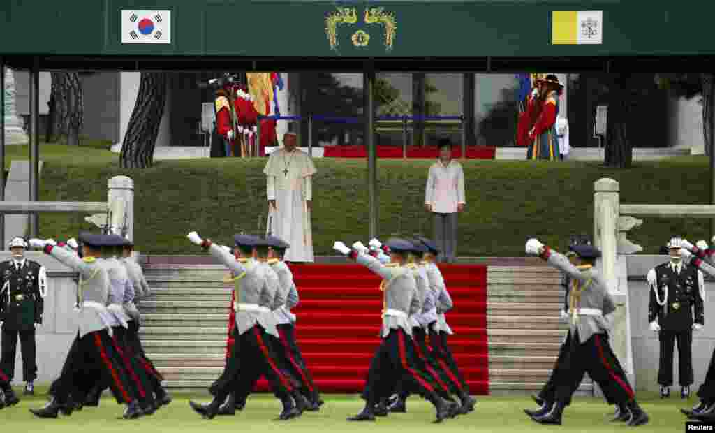 Pope Francis and South Korean President Park Geun-hye inspect South Korean honor guards during a welcoming ceremony at the presidential Blue House in Seoul, Aug. 14, 2014.